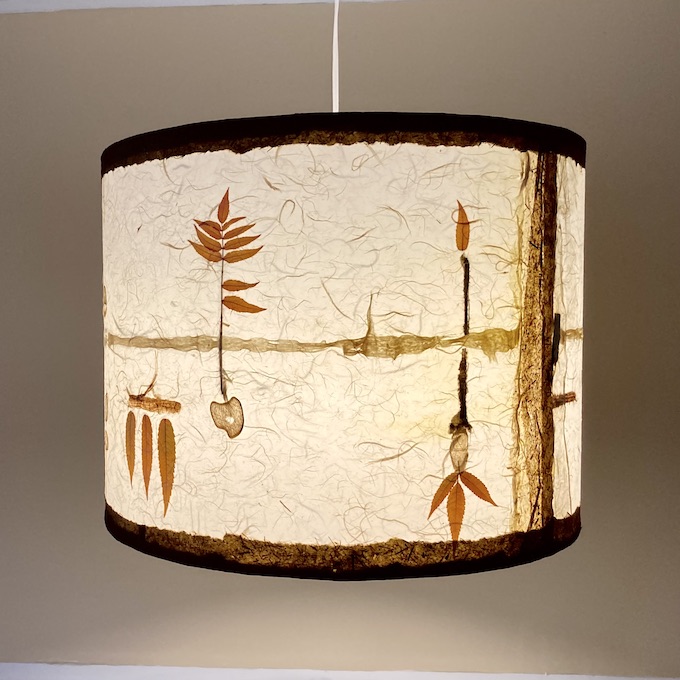 one lit hanging drum pendant in geometric style with autumn leaves