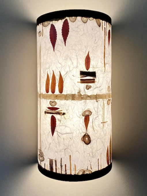 one lit sconce with leaves and fibers